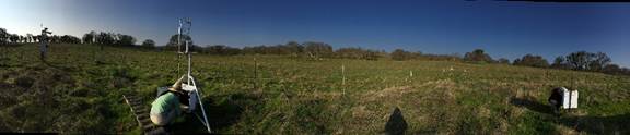 Panorama of pasture with someone working at eddy tower