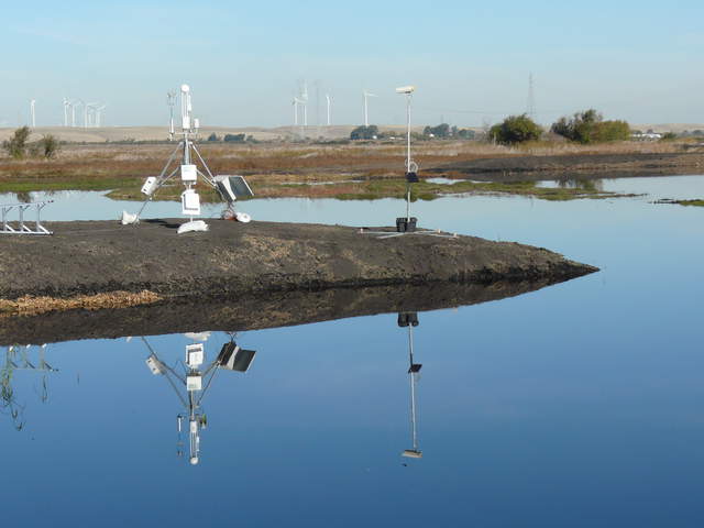 Eddy tower and camera post reflected in water