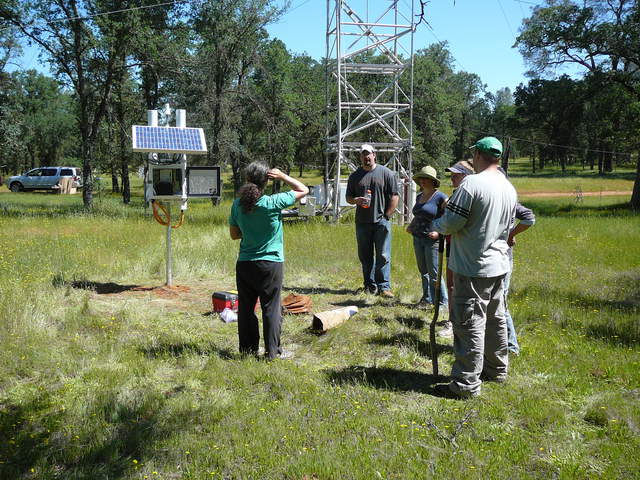 People discussing installation of COSMOS soil moisture sensor