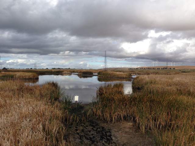 Low water level and a vague rainbow in the sky