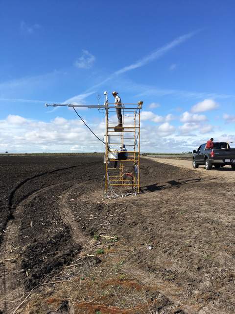 Kyle and Daphne on the newly installed corn tower. The corn field is still bare soil.