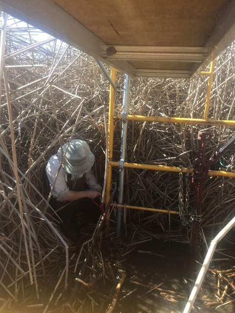 Joe leveling the WP scaffolding by jacking up the tower, attaching new legs onto the tower, and positioning concrete pier blocks under the water.