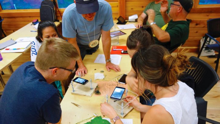 Stella Cousins showing how to make do-it-yourself miniature microscopes in a classroom